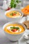 Pumpkin soup with cream and parsley on a grey concrete or stone background