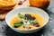 Pumpkin soup with pumpkin seeds, seafood, mussels, shrimps, blue cheese, mold served in bowl, top view