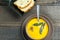 Pumpkin soup with sage leaves in brown ceramic soup plate with garlic bread.