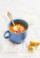 Pumpkin soup served in blue ceramic mug with cream and paprika