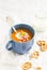 Pumpkin soup served in blue ceramic mug with cream and paprika