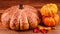 Pumpkin sourdough bread with small pumpkins and autumnal leaves on a wooden background