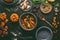 Pumpkin stew with spinach and ginger in cooking pot with spoon and bowl on dark kitchen table background