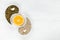 Pumpkin and sunflower seeds lie on a white background with garlic cloves in the form of a Yin-Yang sign, with an orange cut