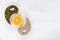 Pumpkin and sunflower seeds lie on a white background with garlic cloves in the form of a Yin-Yang sign, with an orange cut