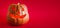 Pumpkin symbol of halloween with candles burning inside on a red background. Copy space