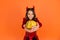 Pumpkin vegetable in hands of happy devil kid wear horns costume of imp on halloween party, selective focus, halloween