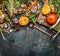 Pumpkin with vegetarian cooking ingredients, wooden spoon on dark rustic background, top view