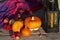 Pumpkins, apples, autumn leaves, rowanberry,  vintage lamp with orange candle and woolen checkered plaid.