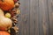 Pumpkins, autumn leaves, anise, acorns, cinnamon border on rustic dark wood. Happy Thanksgiving and Halloween template with space