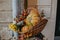 Pumpkins, autumn vegetables and flowers in wicker basket, rustic festive decoration of european city street. Autumn harvest. Happy