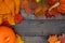 Pumpkins, autumnal maple leaves and pullover on wooden background.