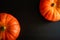 Pumpkins on black wooden table, top view. Halloween background with copy space. Autumn still life with orange pumpkins dark