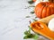 Pumpkins border of various sizes and colors and different raw herbs and spices on marble background Copy space