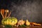 Pumpkins, butternut squash, mushrooms with cooking ustencils and rolling pin on a table over a vintage background with copy space