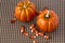 Pumpkins and Candy corn decorations on a brown woven background