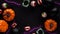 Pumpkins,cauldrons,pots,worms,jaws,spiders and candy in the form of eyes on a black background,top view,copy space.Collection of