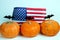 Pumpkins decorated with paper cut bats on a  background of american flag