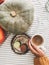 Pumpkins, hand holding hot coffee and macaroons on vintage plate on rustic table, top view. Autumn morning. Fall decor and