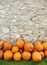 Pumpkins piled against a rustic stone wall