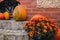 Pumpkins rustic hay decoration outdoors with autumn flowers. Stylish autumn decor of exterior building. Rural decor on