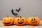 Pumpkins with scary faces near decorative bats on grey background, space for text. Happy Halloween