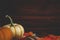 Pumpkins on table with fall foliage against wooden background