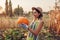 Pumpkins. Young woman farmer picking autumn crop of pumpkins on farm. Agriculture. Thanksgiving and Halloween