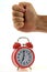 Punching on an alarm clock on a white background