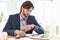 Punctuality is crucial in this office. A handsome businessman checking the time on his watch at his desk.