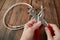 Puncture holes in the strap using a punch and belt on wooden background. Belt Hole Puncher Power Assist Heavy Duty Revolving