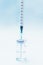 Punctured syringe in a bottle to put a vaccine on blue background