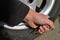 Punctured tire from crash with curb. damaged sidewall and aluminum wheel rim. man with a knife from military special forces shows