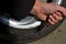 Punctured tire from crash with curb. damaged sidewall and aluminum wheel rim. man with a knife from military special forces shows