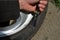 Punctured tire from crash with curb. damaged sidewall and aluminum wheel rim. man with a knife from military special forces shows