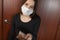 Punishment for leaving the house with self-isolation and quarantine. Unhappy girl in a medical mask holds money to pay a fine at a