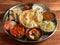 Punjabi Veg Thali from an indian cuisine, food platter consists variety of veggies, lentils, jeera rice, roti, sweet dish, curd,