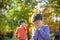 Pupil bullying another in the yard at the elementary school. Older boy offends younger kid. Laughing on his back. Small child