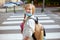 Pupil crossing crosswalk and going to school outdoors in city