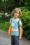 The pupil of elementary school stand on a schoolyard and smiles.