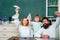 Pupil with paper airplane playing with parents. Pupil of primary school study indoors. Pupil learning letters and