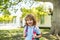 Pupil of primary school with book in hand. Schoolboy with backpack near school outdoors. Beginning of lessons.