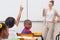 Pupil raising hand in classroom