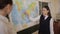 Pupil in school uniform standing near a world map during a geography lesson