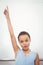 Pupil standing by whiteboard with raised arm