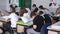 Pupils in the classroom sit with their backs to the camera and write in notebooks - Minsk, Belarus - September 10, 2021