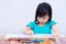 Pupils girl are concentrating on drawing and painting with colored pencils crayon on art paper book. Asian little child learning.