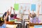 Pupils raising hand during geography lesson in classroom