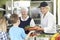 Pupils In School Cafeteria Being Served Lunch By Dinner Ladies