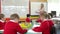 Pupils Sitting Around Table As Teacher Stands By Whiteboard